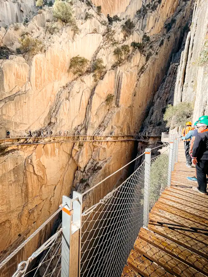 older couple hiking on the wooden trail at el caminito del rey with the tour guide by their side. older couple hiking on the wooden trail at el caminito del rey with the tour guide by their side.